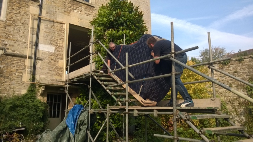 A Grand Piano Removal in action going up scaffolding into a house