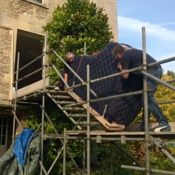 A Grand Piano Removal in action going up scaffolding into a house