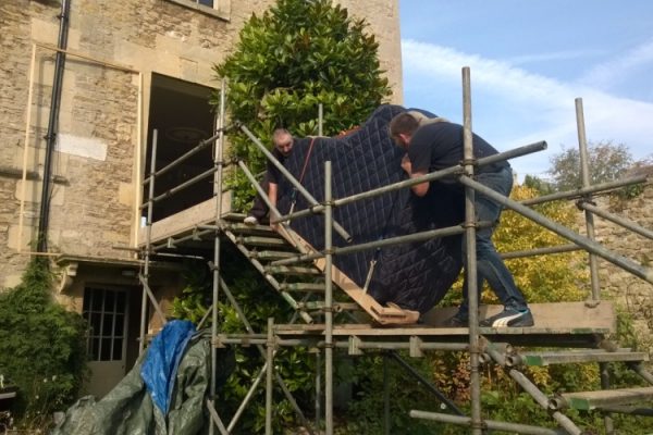 A Grand Piano Removal in action going up scaffolding into a house