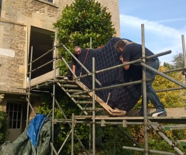 A Grand Piano Removal in action going up scaffolding into a house